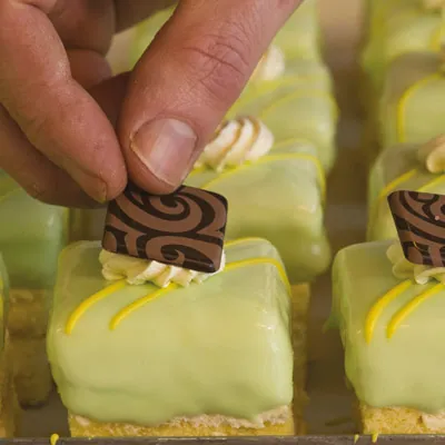 Handen die petitfours versieren